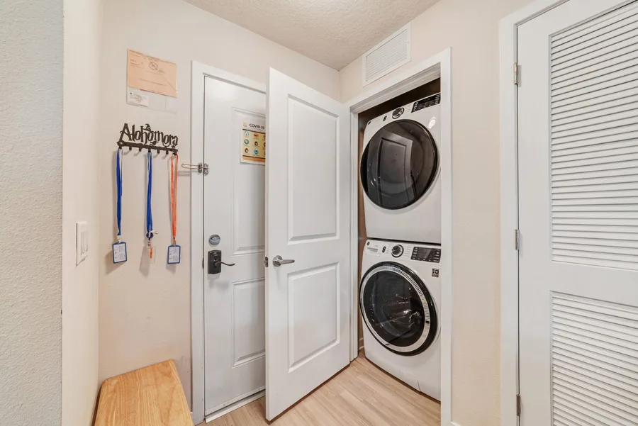 Laundry closet with robes on the wall